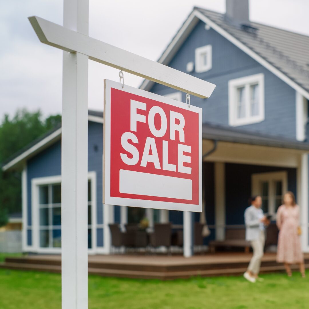 for sale sign in front of a blue house